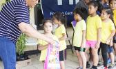 A young participant of the 2017 FFAS Summer Youth League receives her bag filled with school supplies from FFAS executive committee member Saili Ott on July 15 at Pago Park Soccer Stadium. [FFAS MEDIA/Brian Vitolio] 