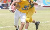 Sam Mikaele of the AYFS Rams trying to evade a tackle from a Packers defender during their season opener last Saturday at the Veterans Memorial Stadium. Mikaele scored the two point conversion that put the Rams over the Packers, 8-6 [photo: TG]
