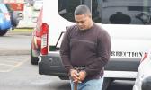 Amosa Lautaimi, handcuffed and making his way to the District Court yesterday morning for his initial appearance