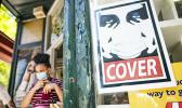 Young woman with mask near masking sign.