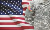 Solier standing in front of American flag.