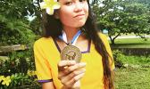 Miss Trish Buenavista, president of the Phi Theta Kappa (PTK) honor society chapter at ASCC, displays her PTK medallion. She has recently been chosen by the PTK administration to serve as a regional officer, which will involve organizational duties for regional PTK events. (Read story inside for details. Trish Buenavista HOLDING ptk MEDAL