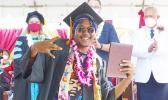 ASCC grad with his diploma, Lt. Gov in the background