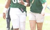 ASHSAA ATC Florence Wasko walking an injured Leone player off the field for a check up, during a time out in the second half of Leone and Nu’uuli’s varsity match up last Saturday afternoon.  [photo: TG]