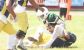 Iverson Ta’ase of Leone is stopped immediately in the backfield by Branson Pualau of Nu’uuli during the second quarter of their varsity match last Saturday. Ta’ase and the Lions won 32-0.  [photo: TG]