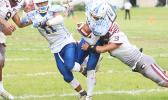 Kalisi Lotulelei of Samoana is stopped by Tafuna's middle linebacker at the line of scrimmage during the opening quarter of their varsity championship game last Saturday morning. Lotulelei helped the Sharks to a 7-6 victory over Tafuna. [photo: TG]