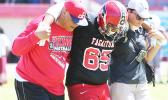 An injured Faga’itua player is escorted off the field by Vikings coach Jimmy Grey and ATC Florence Wasko during the Vikings vs. Warriors JV match last Saturday. [photo: TG]