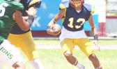 Wildcats quarterback, Diamond Vea scrambling with the football, after failing to find an open receiver for a pass during the second quarter of their varsity match up against the Lions. The Wildcats were shut out in 32- 0 loss.  [photo: TG]