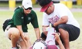 An injured Tafuna Warrior being tended to by ATC Florence Wasko and Warriors assistant coach Travis Pavihi during the opening quarter of the Warriors vs. Sharks JV match up last Saturday morning.  [photo: TG]