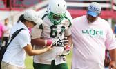 An injured Leone Lion is walked off the field while being checked out by ASHSAA ATC Florence Wasko during the first half of a JV game last Saturday morning at the Veterans Memorial Stadium.  [photo: TG]