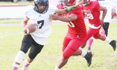Nathaniel Maea of Nu’uuli trying to escape a sack in the backfield by a Viking defender during the third quarter of their JV match up last Thursday evening where Nu’uuli collected their first win of the season after defeating the Vikings 14-6.  [photo: TG]