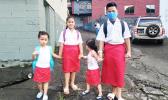 Matafao Elementary School students holding hands on their way to school