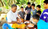 Youngsters watch as palusami is prepared for the umu