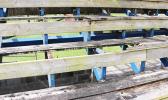 The wooden seating area at the baseball field is in such a rotted state, thanks in part to vandalism that has also left the seats with burn marks, and broken/splintered wood pieces. [photo: THA]