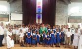 Several students and faculty members of St. Theresa Elementary School surround Bishop Peter Brown