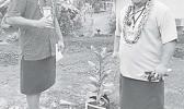  AS-EPA deputy director William Sili and AS-EPA finance and special projects manager, Victor Tuiasosopo next to a plant with a photo of the American Samoa flag.