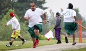 John Reno Sagaga, second from left, passes teammate Onosai Sanerivi after Sagaga hit the ball during a kirikiti game at Jefferson Park. (Ellen M. Banner / The Seattle Times) John Reno Sagaga, second from left, passes teammate Onosai Sanerivi