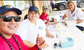 Three HR staffers manning a Tonga relief donation booth