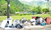  various types of garbage being dumped under and near the pole