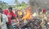  A photo taken on February 6, 2013 shows a crowd watching as a young mother accused of sorcery, is stripped naked, reportedly tortured with a branding iron, tied up, splashed with fuel and set alight on a pile of rubbish topped with car tyres, in Mount Hagen city in the Western Highlands of Papua New Guinea. [Photo: AFP / Post Courier via RNZI] 