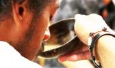Man takes a sip of kava from the bowl.
