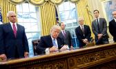   Donald Trump, seated, signed, three executive orders on Monday, including one banning any US-funded organisations from speaking about abortion. [Photo: AFP via RNZI] 