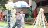 Two ASG employees hang Christmas lights at the EOB