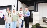 Taetuli and family in front of their new home.
