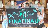 Finafinau members with sign saying save our land, protect our ocean, empower our people
