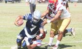 Samoana Sharks quarterback Viliamu Tanielu is brought down by three Tafuna Warrior defenders