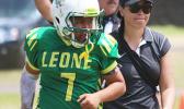 ASHSAA ATC Florence Wasko helping injured Leone Lions quarterback Isaiah Elisara off