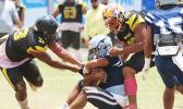 Charlie Toa Leama of Nu’uuli and a teammate sack Samoana’s quarterback Viliamu Tanielu