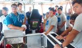USCG official Frank Thomsen with a group of local teens who toured the USCG Cutter Joseph Gerczak