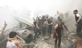Palestinians remove a dead body from the rubble of a building after an Israeli airstrike