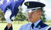 Senior Airman Darias Faaita preparing to present an American Flag to its recipient.