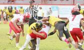 Faga'itua Vikings ball carrier Roy Ulugalu is tackled by two Nu’uuli Wildcat defenders 