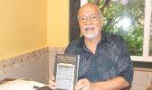 Author Fuimaono Fini Aitaoto holds a copy of his new book