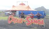 Employees of The Magic Circus of Samoa posing with their sign