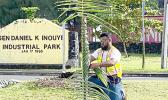 The  Sen. Daniel K. Inouye Industrial Park sign with man 