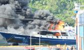 The Jeanette on fire and being towed out of the harbor