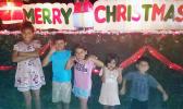 The Uelese siblings in front of a Merry Christmas display in Aoloau
