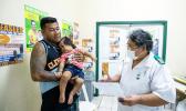 Nurse Fa'atafa Tavita (R) speaking with a father holding his child at the Apia Town Clinic