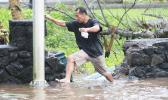 A man in Fagaalu navigating a flooded sidewalk area last week Friday — a typical sight during the aftermath of Tropical Storm Gita that hit the territory last Friday, followed up by a monsoon trough that dumped buckets of rain with high winds throughout the weekend.  [photo: TG]
