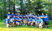 the Manu Bears rugby team, shows team officials and players posing for a photo