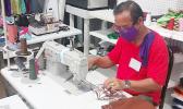 A worker at Manu'a Store sewing protective face masks