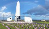 Small American Flags in front of Veterans Memorial Monument with rainbow overhead