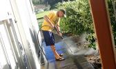 Niulaititi Hopkinson power washing the area outside of the Fatuoaiga Montessori School