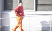 One of the four DPS officers, assigned to the Juvenile Detention Center, heading into the District Court last Friday morning for his initial appearance after being arrested last Thursday for alleged illegal activities at the Center. When the officer appeared in the courtroom his hands were in handcuffs.  [photo: AF]