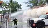 Firemen spraying water on storage tanks