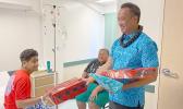A young man named Troy receives a gift from Paul Young on behalf of Rotary Club of Pago Pago